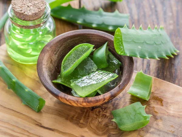 Fresh aloe leaves and aloe gel in the cosmetic jar on wooden tab — Stock Photo, Image