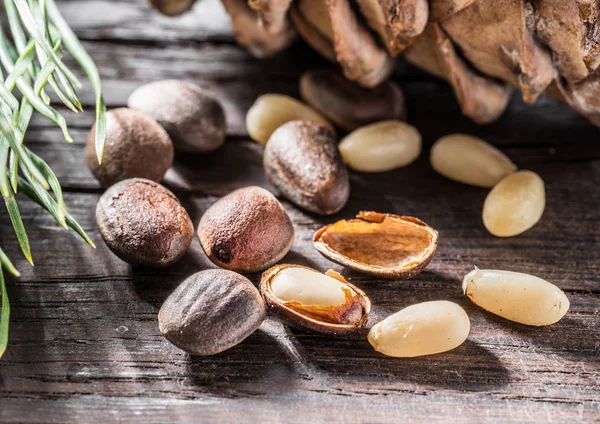 Pinienkerne auf dunklem Holztisch. Bio-Lebensmittel. Makro. — Stockfoto