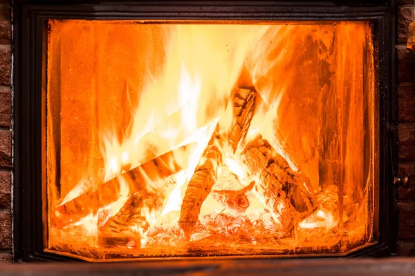 Wooden table top and burning warm fire at the background. — Stock Photo, Image