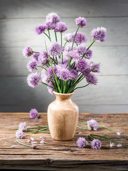 Bouquet of onion (chives) flowers in the vase on the wooden tabl — Stock Photo, Image