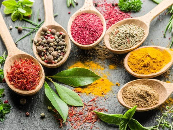 Assortment of colorful spices in the wooden spoons. — Stock Photo, Image