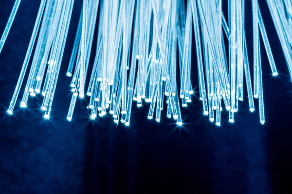 Bundle of optical fibers with lights in the ends. Blue backgroun — Stock Photo, Image
