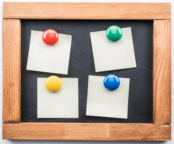 Tafel und Post-it-Scheine mit bunten Magneten befestigt. — Stockfoto