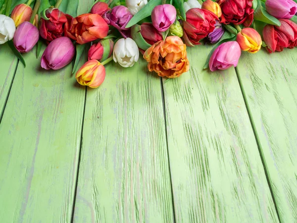 Bouquet colorato di tulipani su sfondo verde in legno . — Foto Stock