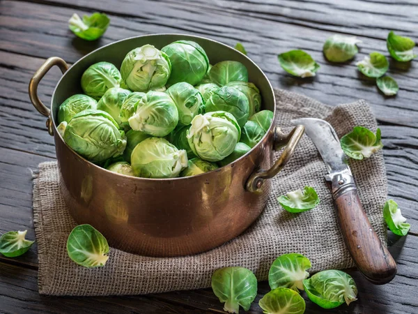 Eski ahşap masa üzerinde bakır tavada Brussel lahanası. — Stok fotoğraf