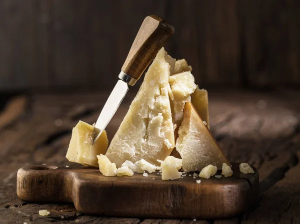 Piece of Parmesan cheese and cheese knife on the wooden board. D — Stock Photo, Image