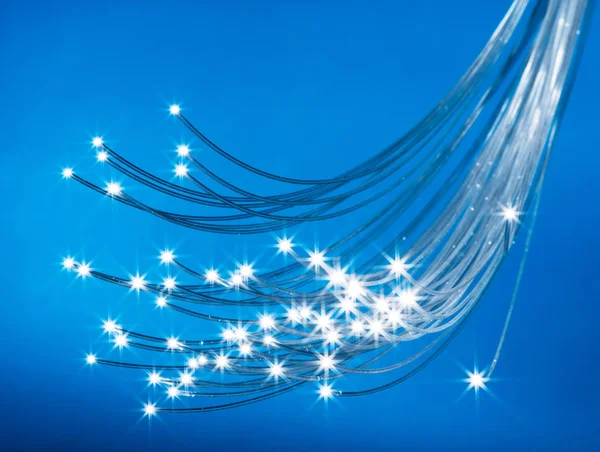 Fascio di fibre ottiche con luci alle estremità. Backgroun blu — Foto Stock