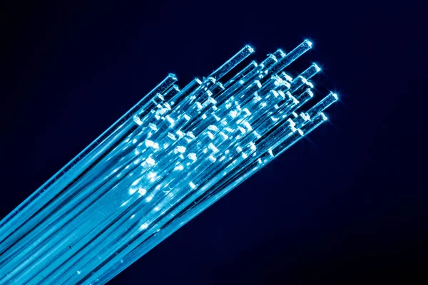 Bundle of optical fibers with lights in the ends. Blue backgroun — Stock Photo, Image