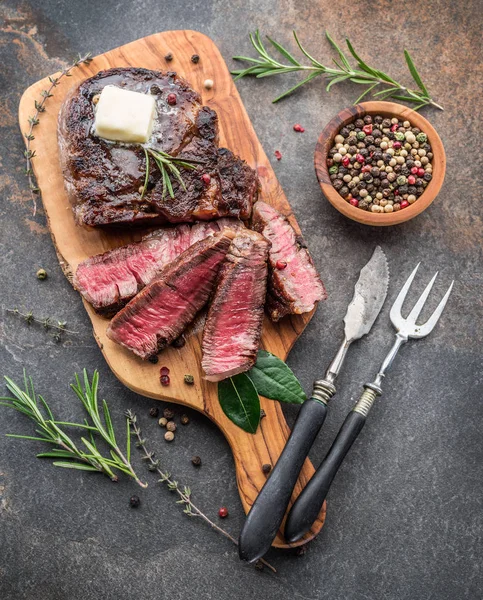 Bistecca Ribeye media rara con erbe aromatiche e un pezzo di burro sul — Foto Stock