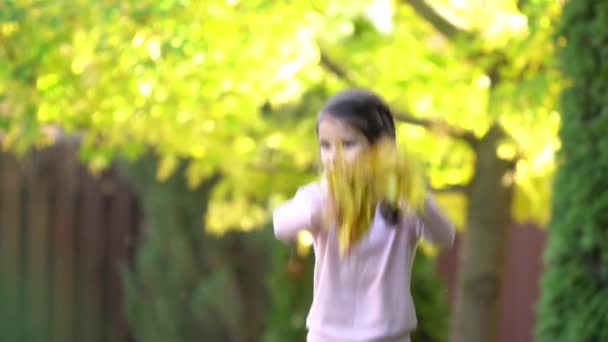 户外的女孩正在玩耍 与秋叶一起欢欣鼓舞 慢动作 — 图库视频影像