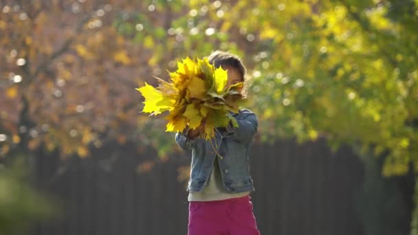 屋外の女の子が遊んで 秋の葉で喜んでいます 4Kビデオ — ストック動画