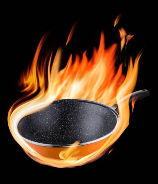 Siyah arka plan üzerinde alevler içinde yanan boş wok pan.