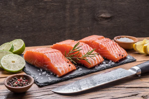 Fillet salmon segar pada papan potong hitam dengan herbal dan rempah-rempah — Stok Foto