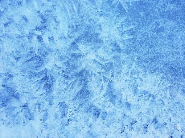 Sneeuwkristallen vormen een mooi sneeuw patroon op bevroren ijzige rivier. S — Stockfoto
