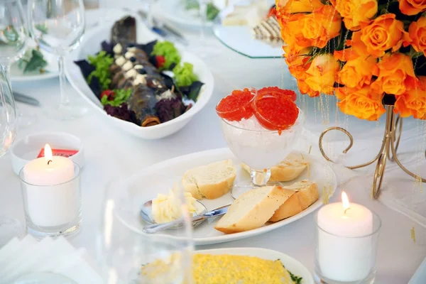 Instelling van de tabel van de vakantie versierd met bloemen en kaarsen. — Stockfoto