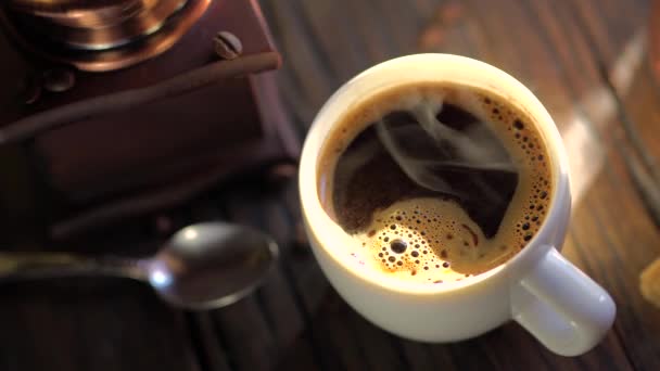 Kávés csésze frissen főzött kávéval egy régi vintage asztalon. Gőz emelkedik ki a csészéből. 4k videó.