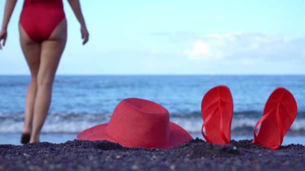 Kvinna Röd Baddräkt Och Hatt Går Havet Svart Sandstrand Röda — Stockvideo