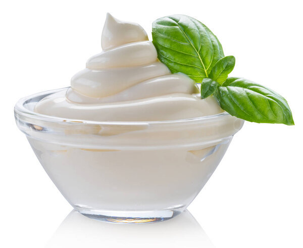 Майонез кружится в стеклянной чаше и листьях базилика. Обрезной путь
.