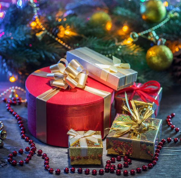 Piękne prezenty świąteczne w urządzonych pudełkach w pobliżu Boże Narodzenie tr — Zdjęcie stockowe