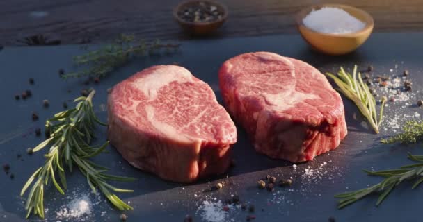 Dos Filetes Costilla Cruda Con Especias Hierbas Una Superficie Piedra — Vídeos de Stock