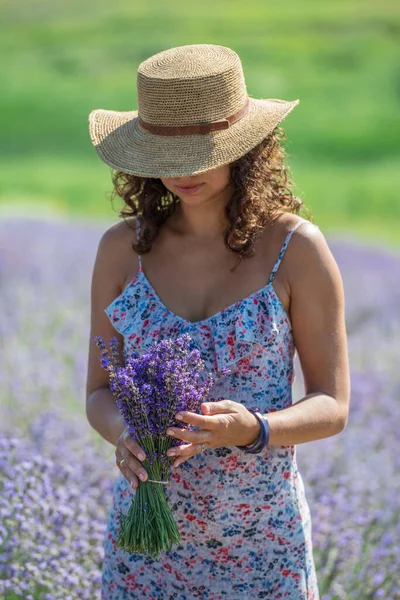 一束盛开的薰衣草在女人的手里 背景中的薰衣草场 — 图库照片