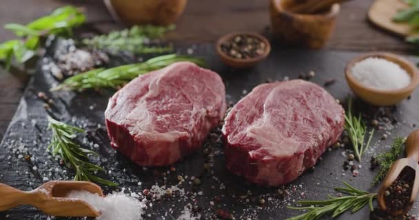 Dva Syrové Žebírkové Steaky Kořením Bylinkami Kamenném Povrchu Kamera Pomalu — Stock video