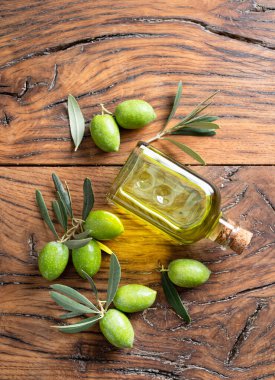 Eski ahşap bir masada zeytin yağıyla yeşil doğal zeytin.. 