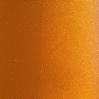 Soğutulmuş bir bardak bira. Soğuk cam yüzeyine küçük su damlaları.