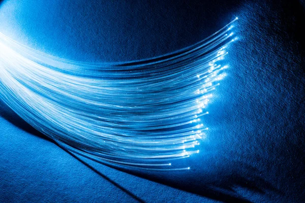 Ucunda Işık Olan Bir Yığın Optik Iplik Mavi Arkaplan — Stok fotoğraf