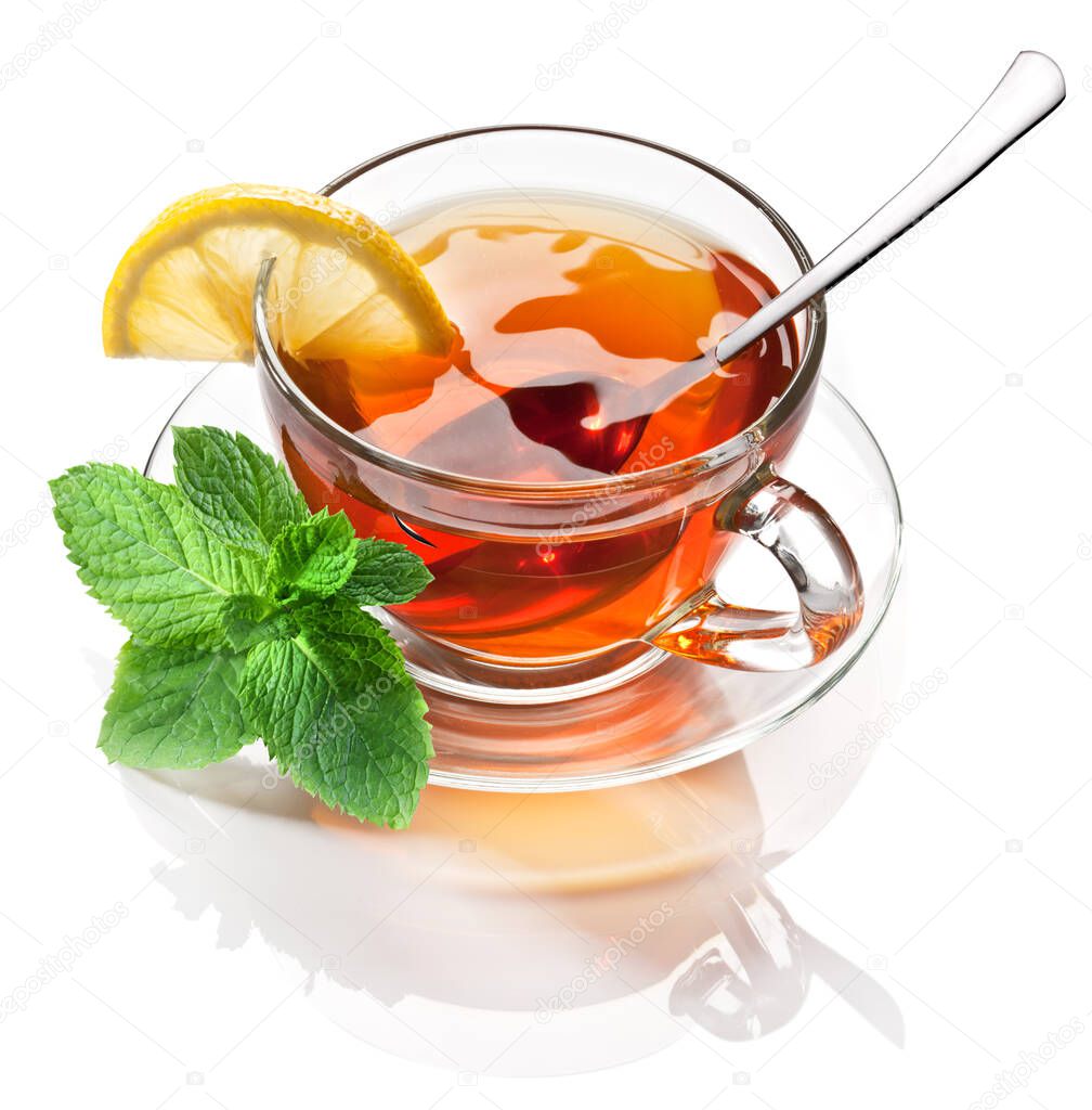 Glass cup with black tea, a slice of lemon and mint leaves isolated on a white background.