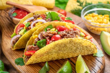 Tahta servis tahtasının yanında Meksika usulü et, tortilla ve limon dilimleri.. 