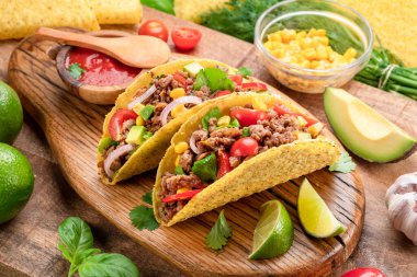 Tahta servis tahtasının yanında Meksika usulü et, tortilla ve limon dilimleri.. 