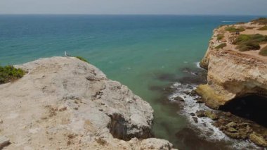 Portekiz 'in güneyindeki Algarve kıyısındaki ünlü Benagil Mağarası' nın turkuaz suları ve dramatik kireçtaşı kayalıkları. Bu ikonik deniz mağarası Avrupa 'nın en popüler doğal cazibelerinden biridir.