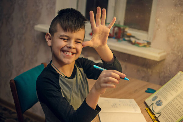 Young boy sitting at the table doing his school homework
