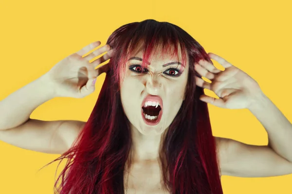 Screaming woman .emotions with halloween makeup and red hair on isolated orange background