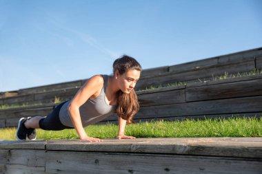 Egzersiz yapan bir kadın, dışarıda şınav çeken bir kadın.