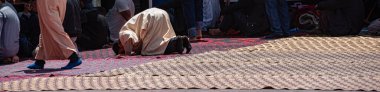 Moroccan praying in ramadan on carpet, posture mujut, copy space clipart