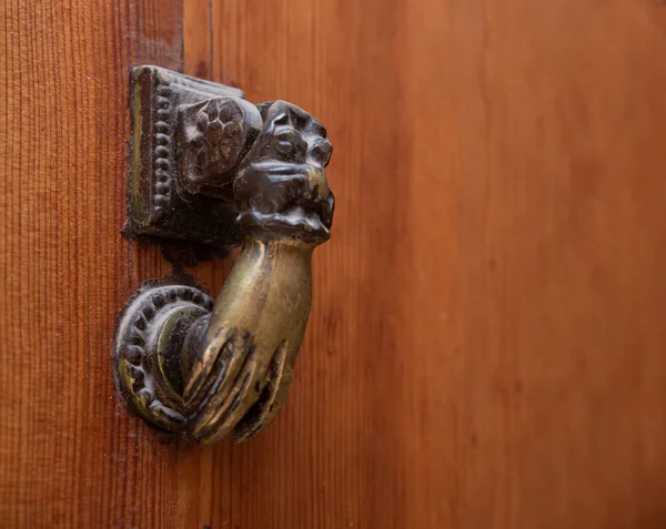Bronze door knocker by the hand of Fatima, wooden background