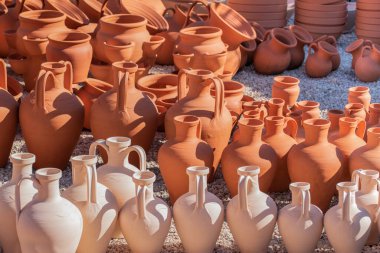 Güneşin altında farklı şekillerde kil sürahiler.