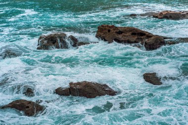Dalgalar kayalara çarpıyor.