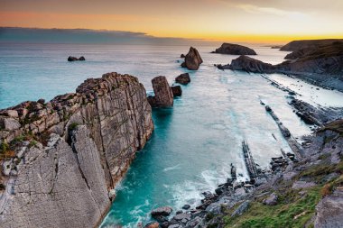 Gün batımında kıyı ve okyanus manzaraları