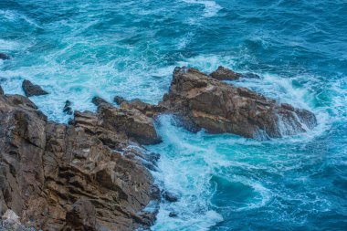 Dalgalar kayalara çarpıyor.