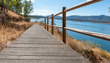 Su deposunun kenarına doğru raylı yaya köprüsü olan doğal çevrenin manzarası