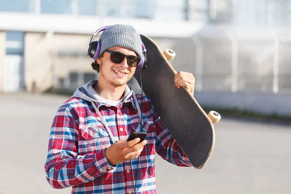 Muž s Skateboard a telefon — Stock fotografie