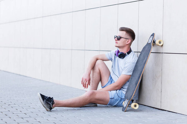 Man with Longboard Before Wall