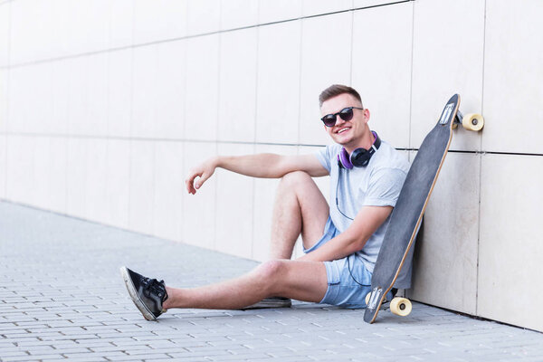 Man with Longboard Near Wall