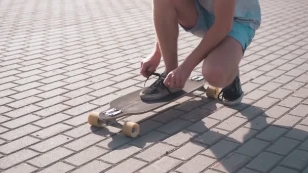 Junge macht sich bereit, Skateboard zu fahren — Stockvideo