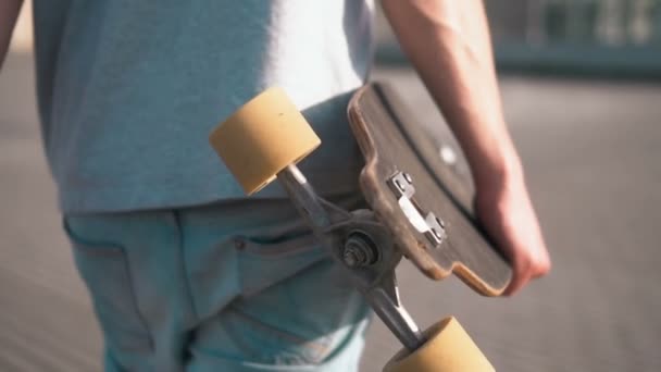 Skateboarder hält Skateboard in der Hand — Stockvideo