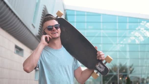 Skateboarder fala no telefone após passeio — Vídeo de Stock