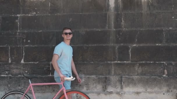 Teenager läuft mit Fahrrad nahe Mauer — Stockvideo